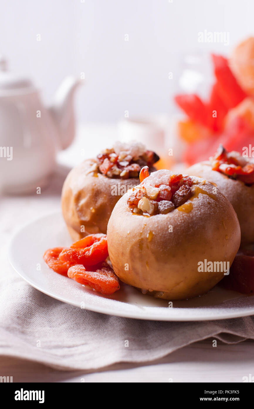 Gebackene Äpfel mit Zimt, Nüssen und Honig auf einem weißen Hintergrund. Herbst oder Winter Dessert Stockfoto