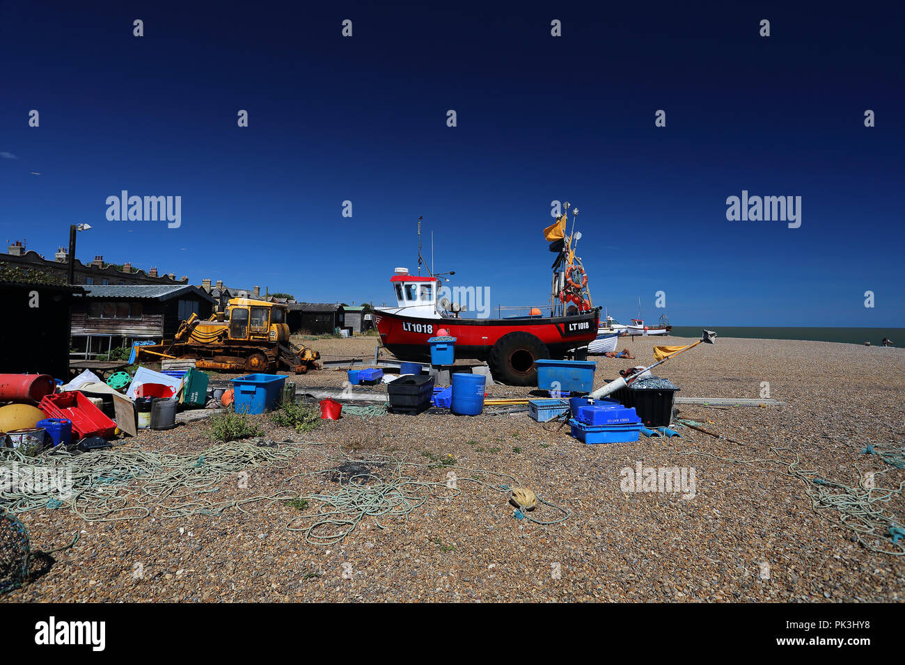 Ein Boot auf den Strand gesetzt auf dem Kiesstrand in Aldeburgh, Suffolk, Großbritannien Stockfoto