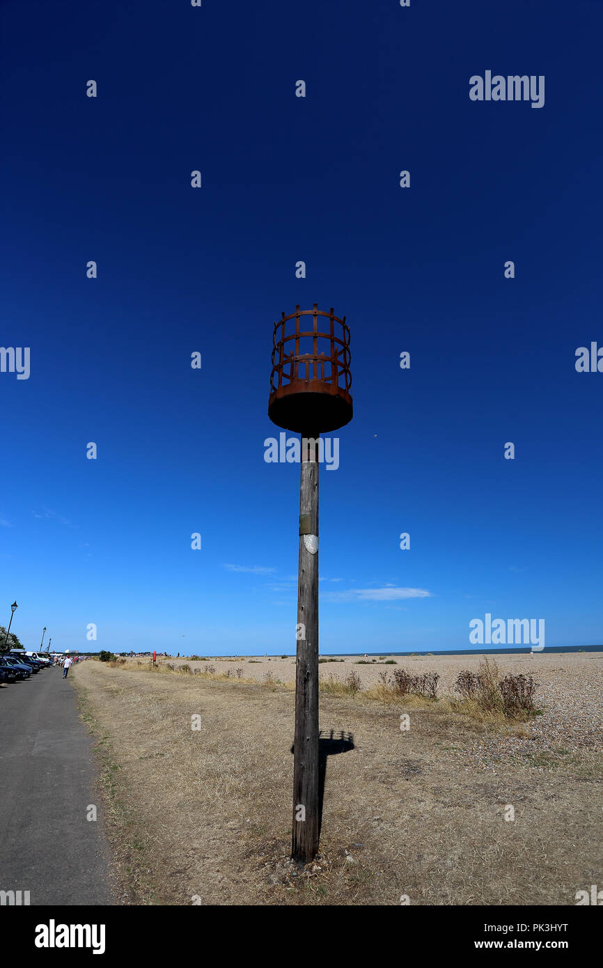 Unkraut im heißen Sommer Sonne hoch um eine alte Signalisierung Beacon neben einer Spur neben dem Kiesstrand in Aldeburgh, Suffolk, Großbritannien Stockfoto