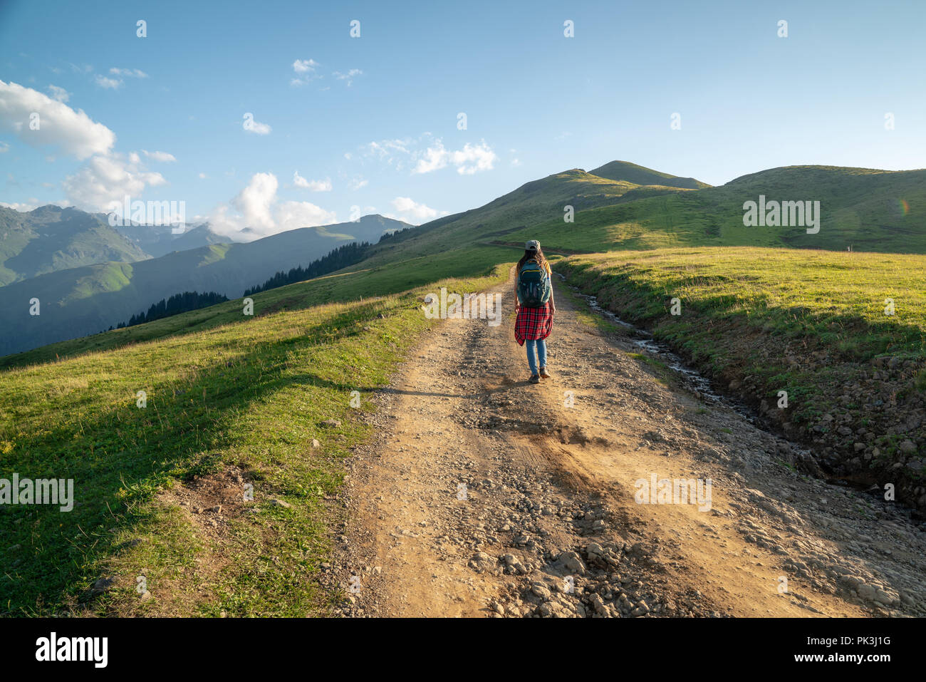 Junge Frau mit Rucksack zu Fuß auf Pfad. Travel Concept. Stockfoto