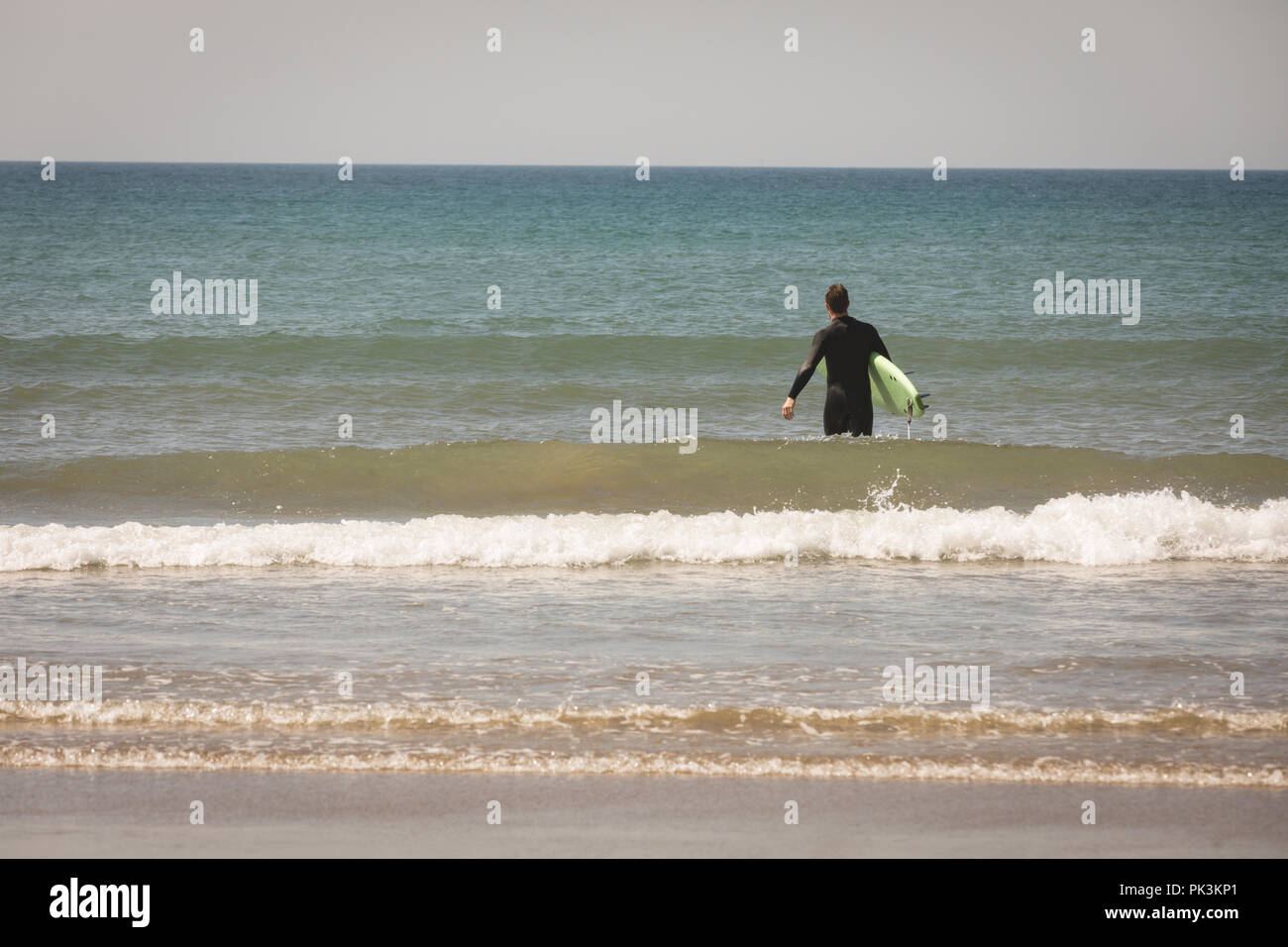 Surfer mit Surfbrett im Meer Stockfoto