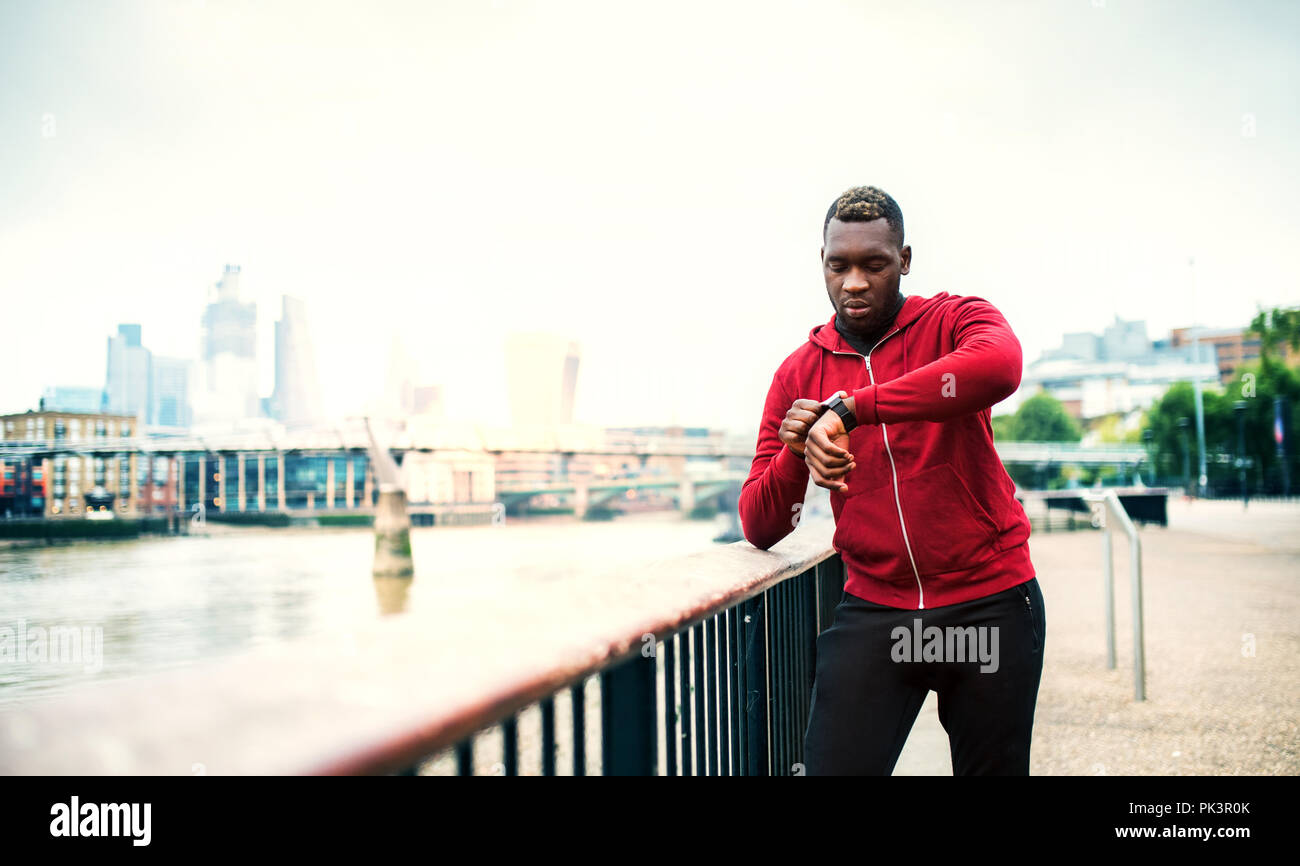 Junge sportliche schwarze Mann Schiene auf der Brücke außerhalb in einer Stadt, Einstellung der Zukunft. Stockfoto