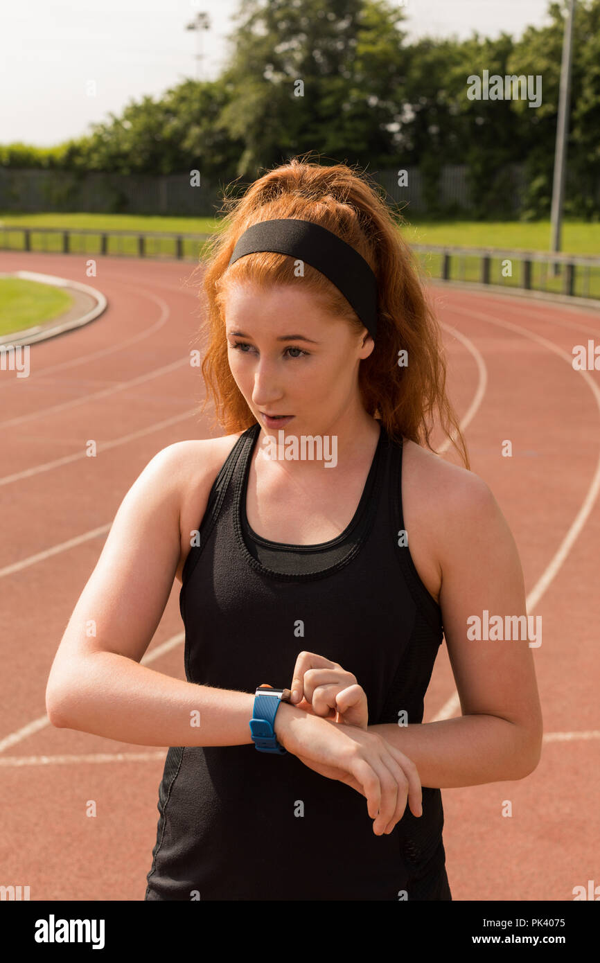 Weibliche athletische mit smartwatch auf der Laufstrecke Stockfoto
