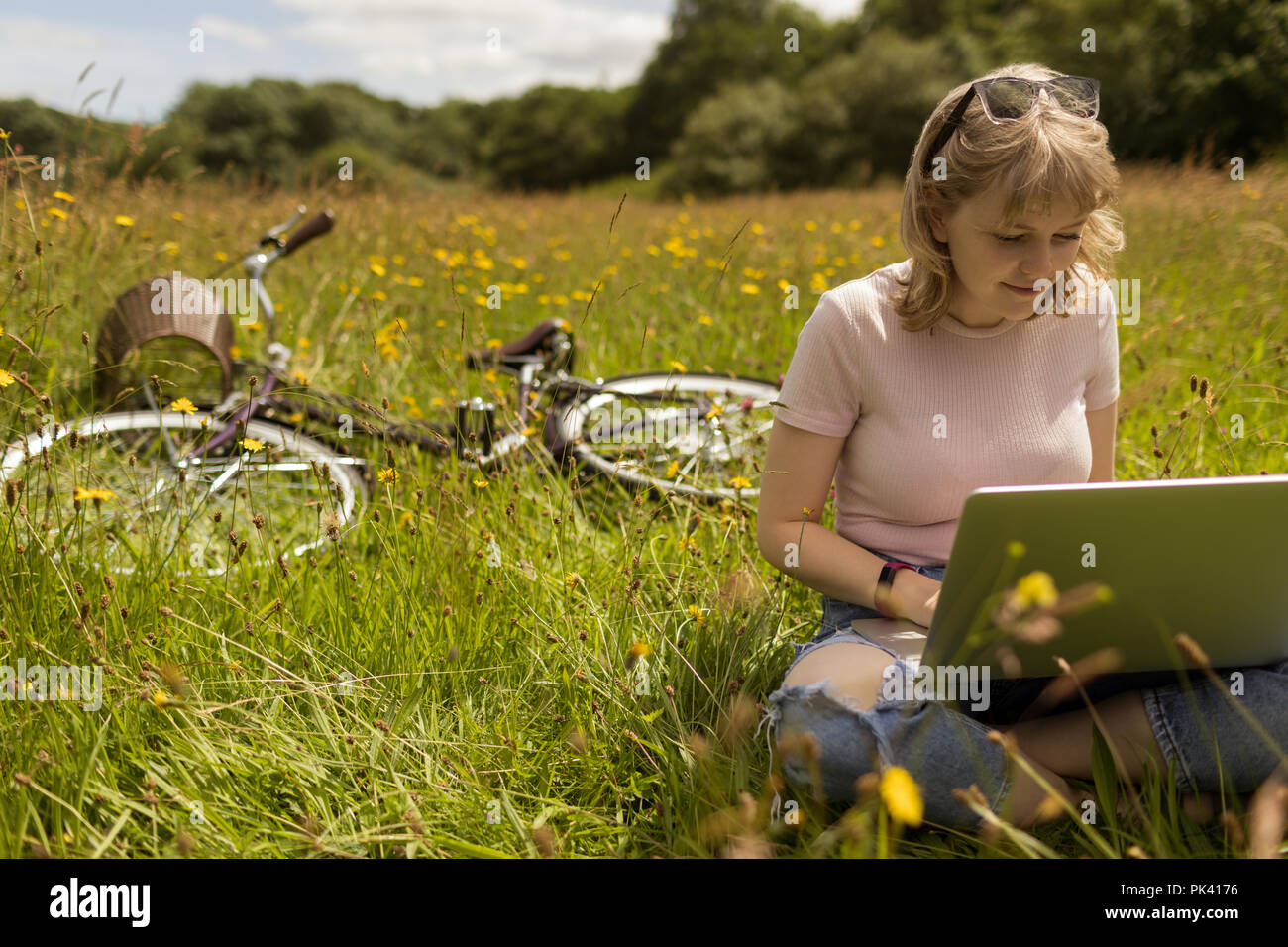 Frau mit Laptop im Feld Stockfoto