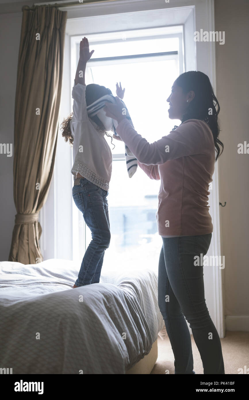 Die Mutter ihrer Tochter helfen beim Tragen Tuch Stockfoto