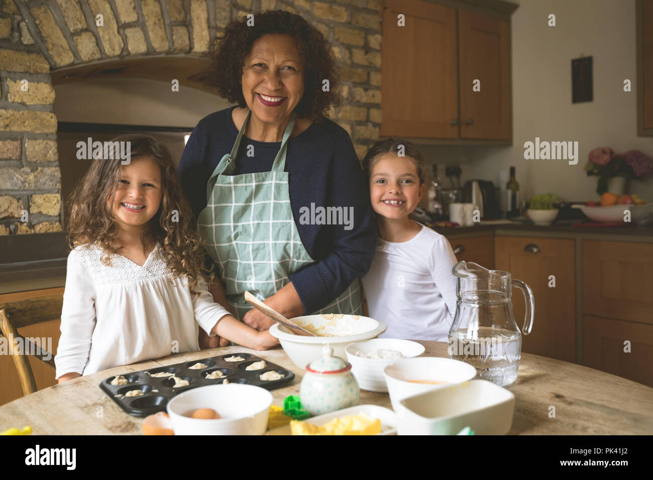 Großmutter stehen mit ihren Enkelinnen in der Küche Stockfoto