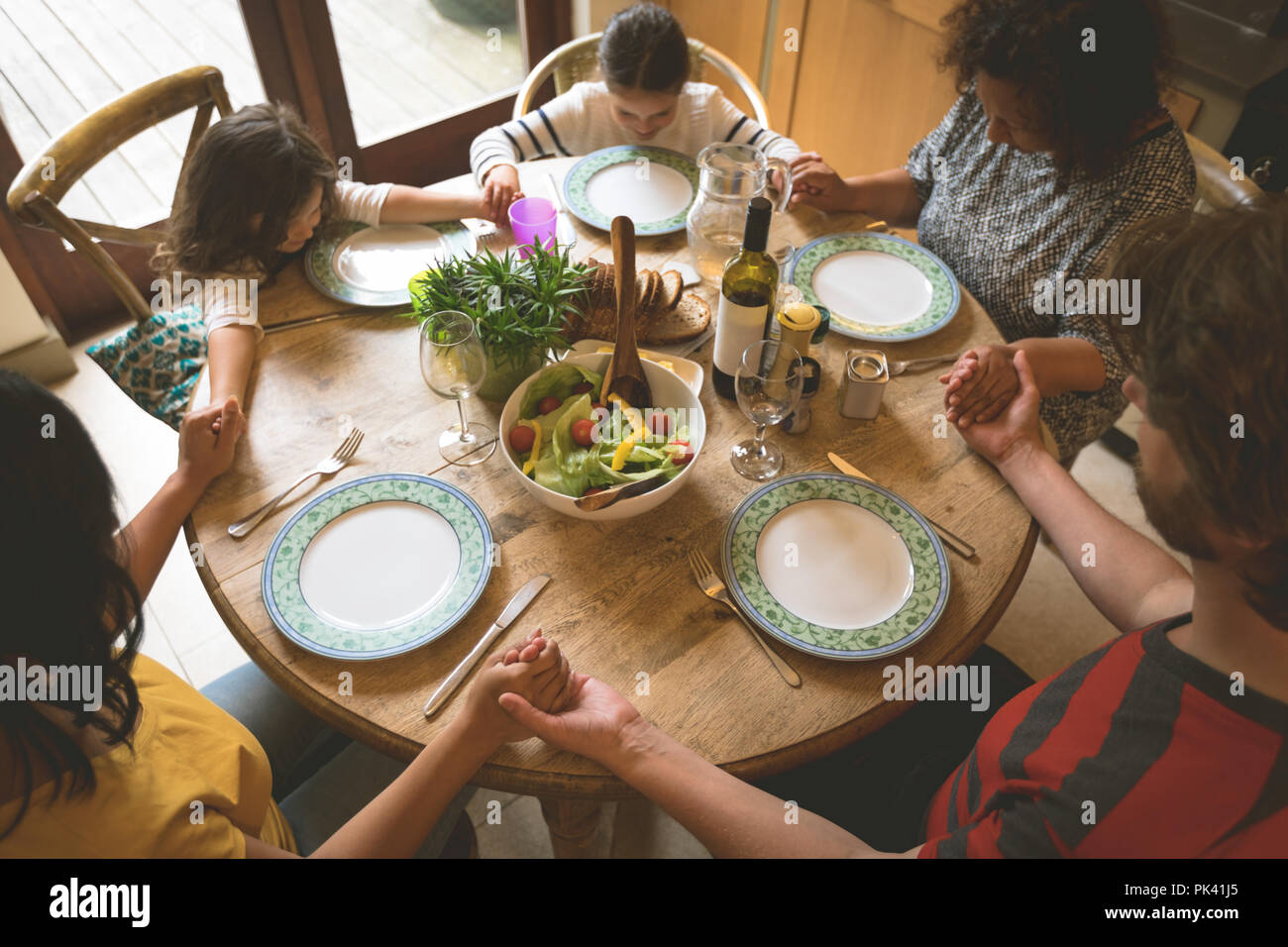Familie beten, bevor Sie eine Mahlzeit Stockfoto