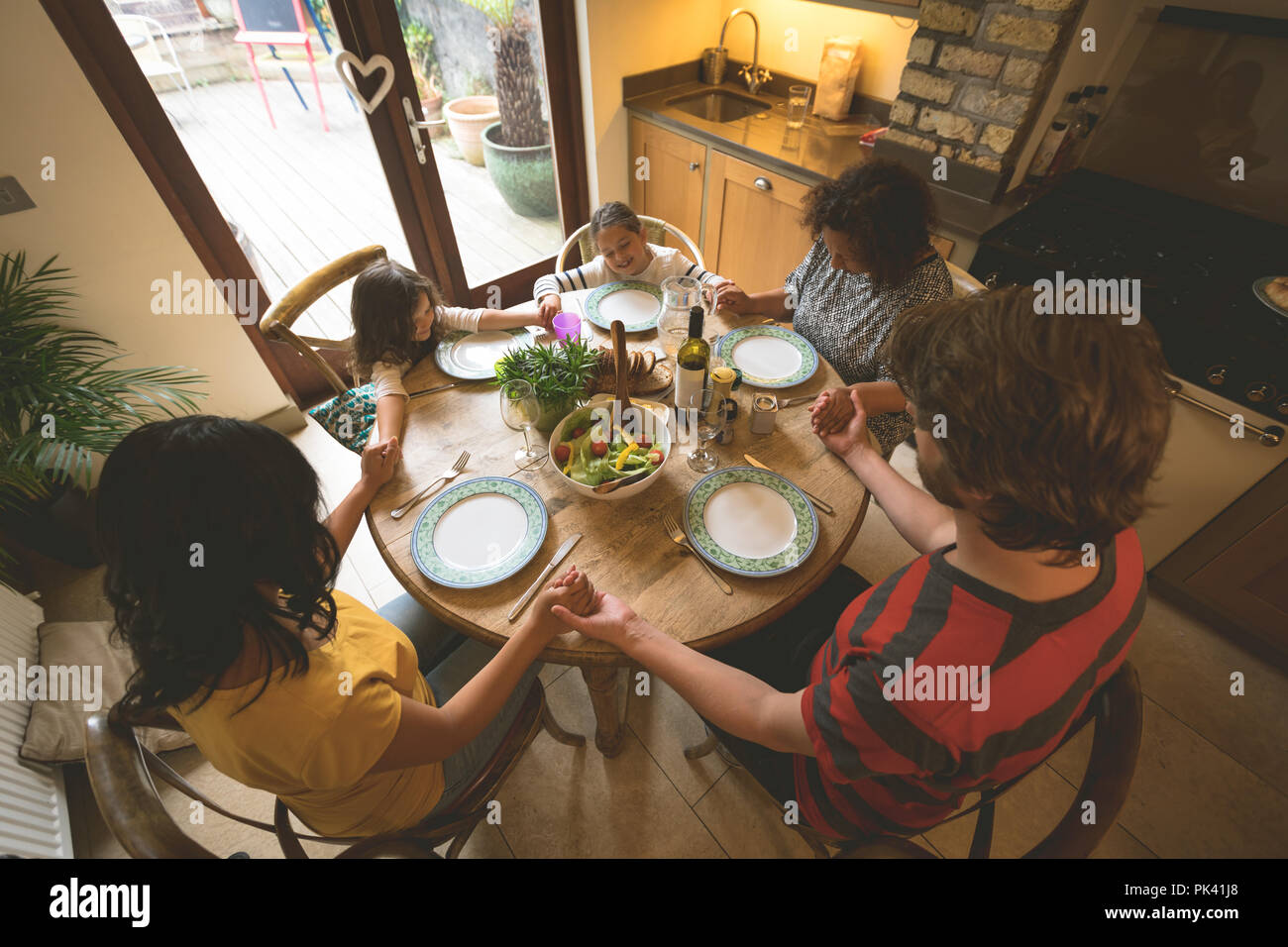 Familie beten, bevor Sie eine Mahlzeit Stockfoto