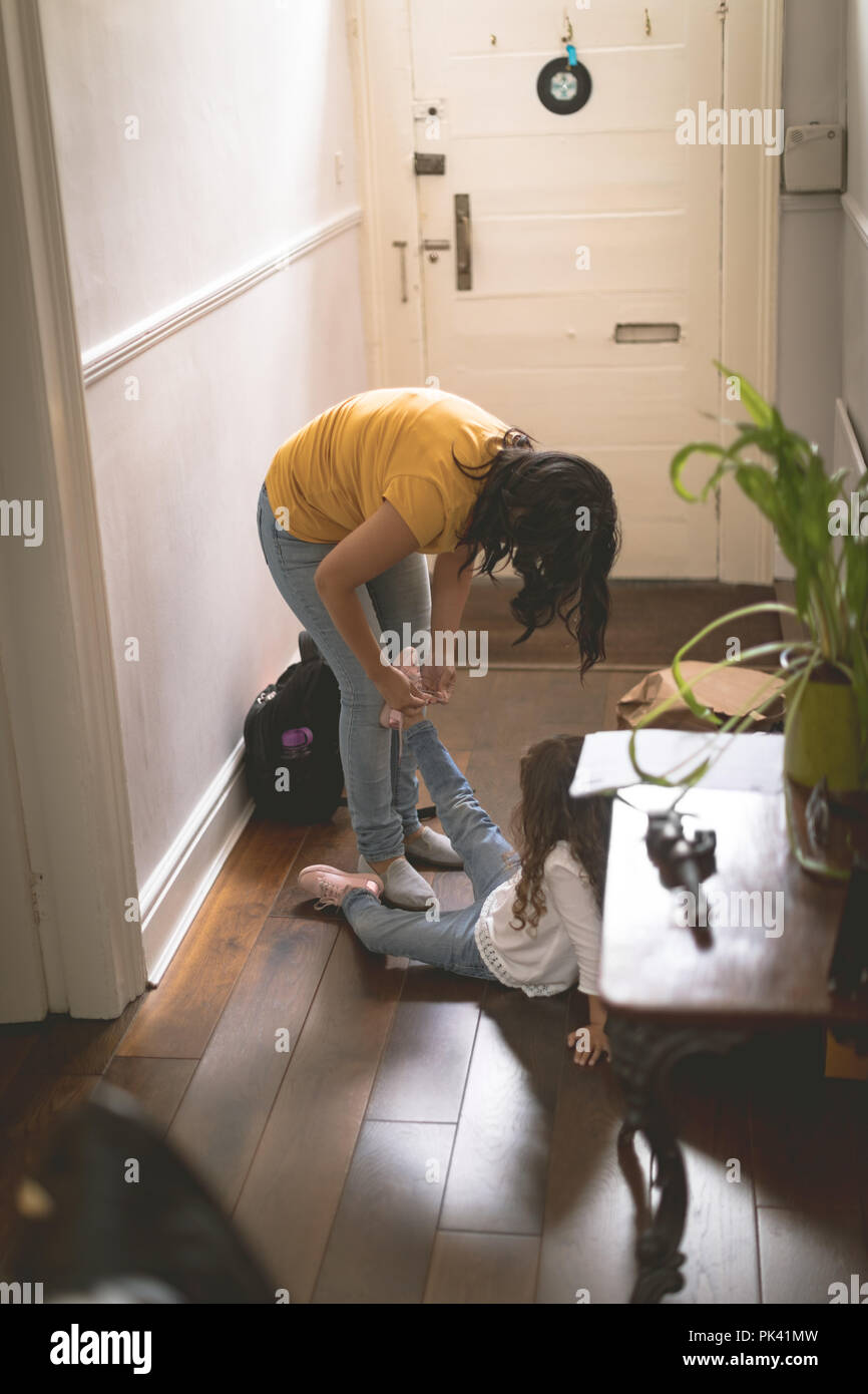 Die Mutter ihre Tochter zu helfen, für das Tragen von Schuhen Stockfoto
