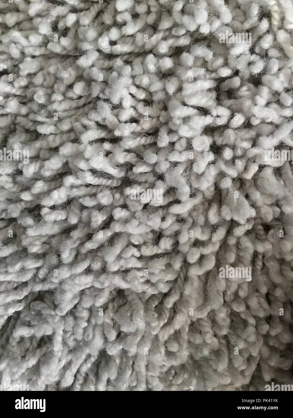 Nahaufnahme von grauem Teppich mit weichen Texturen. Stockfoto