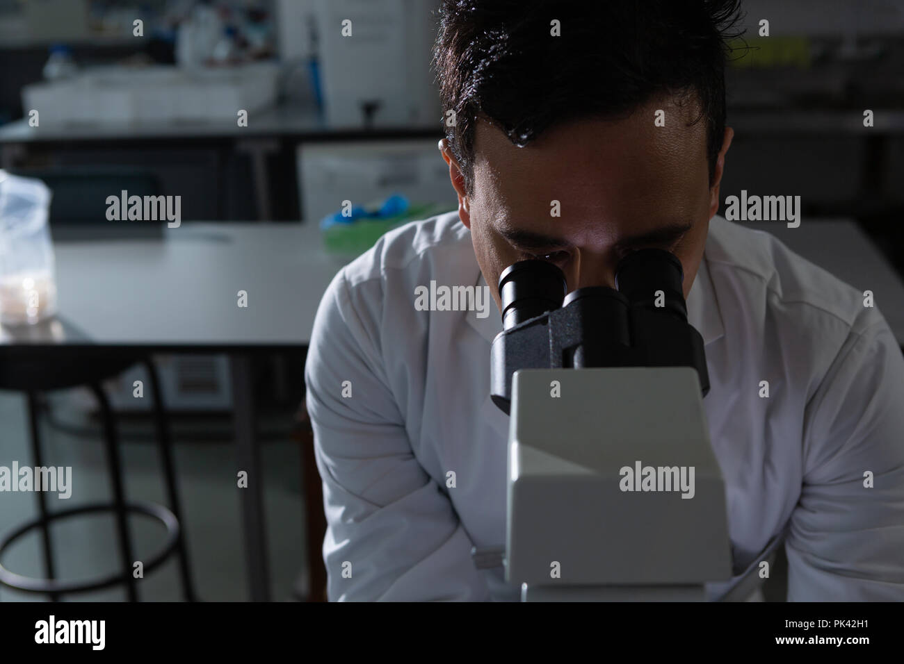 Männliche Wissenschaftler mittels Mikroskop Stockfoto