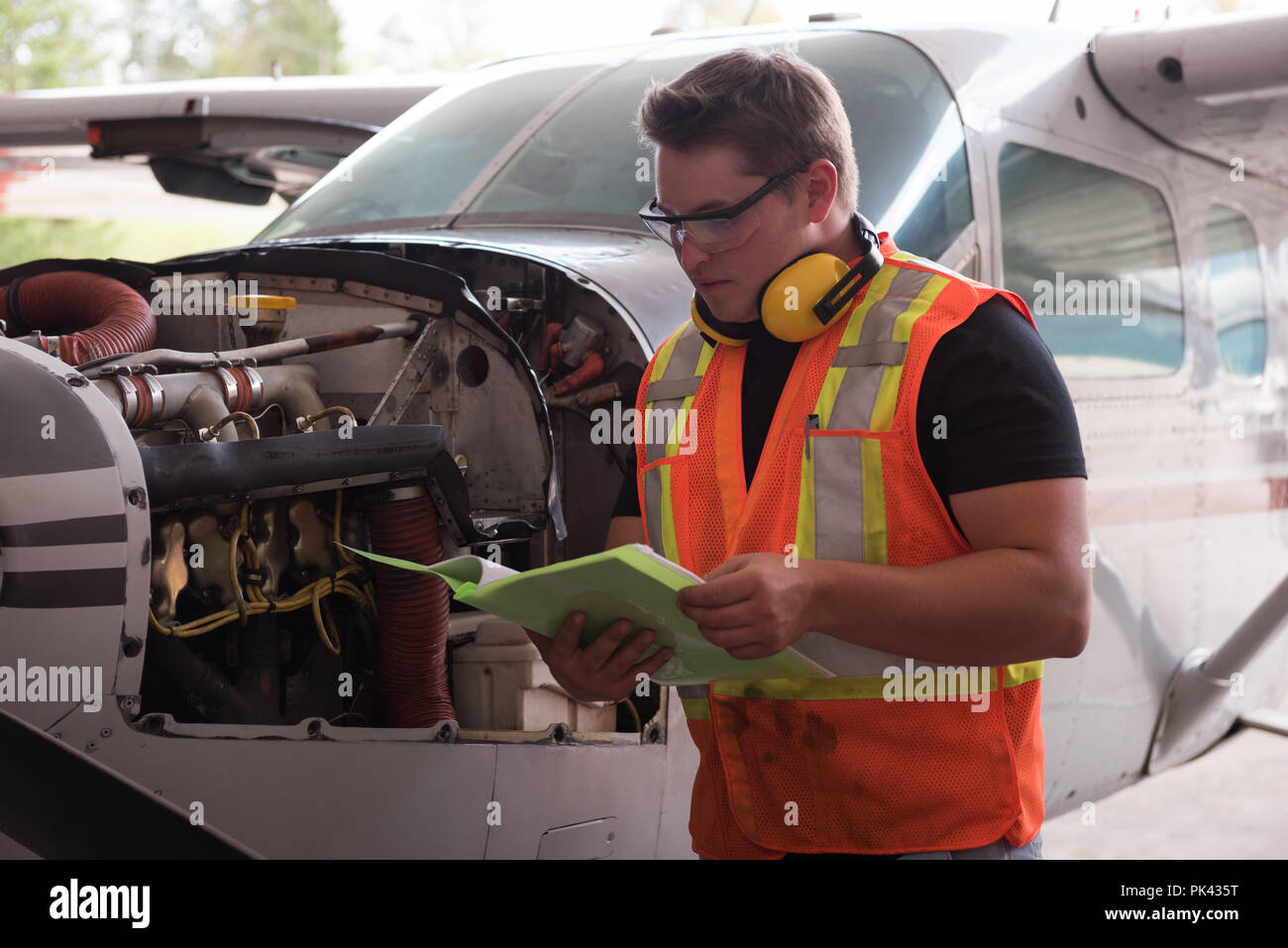 Mechaniker Lesen von Dokumenten im Hangar Stockfoto