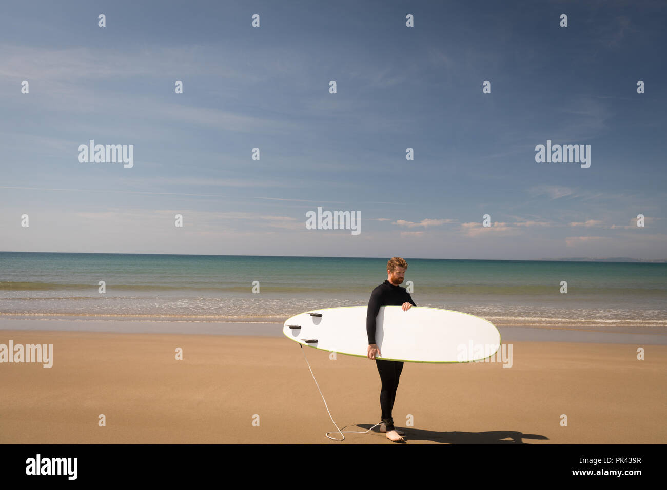Surfer mit Surfbrett am Strand Stockfoto