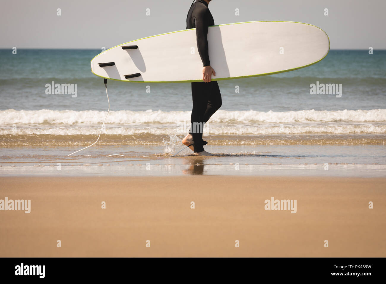 Surfer mit Surfbrett zu Fuß am Strand Stockfoto