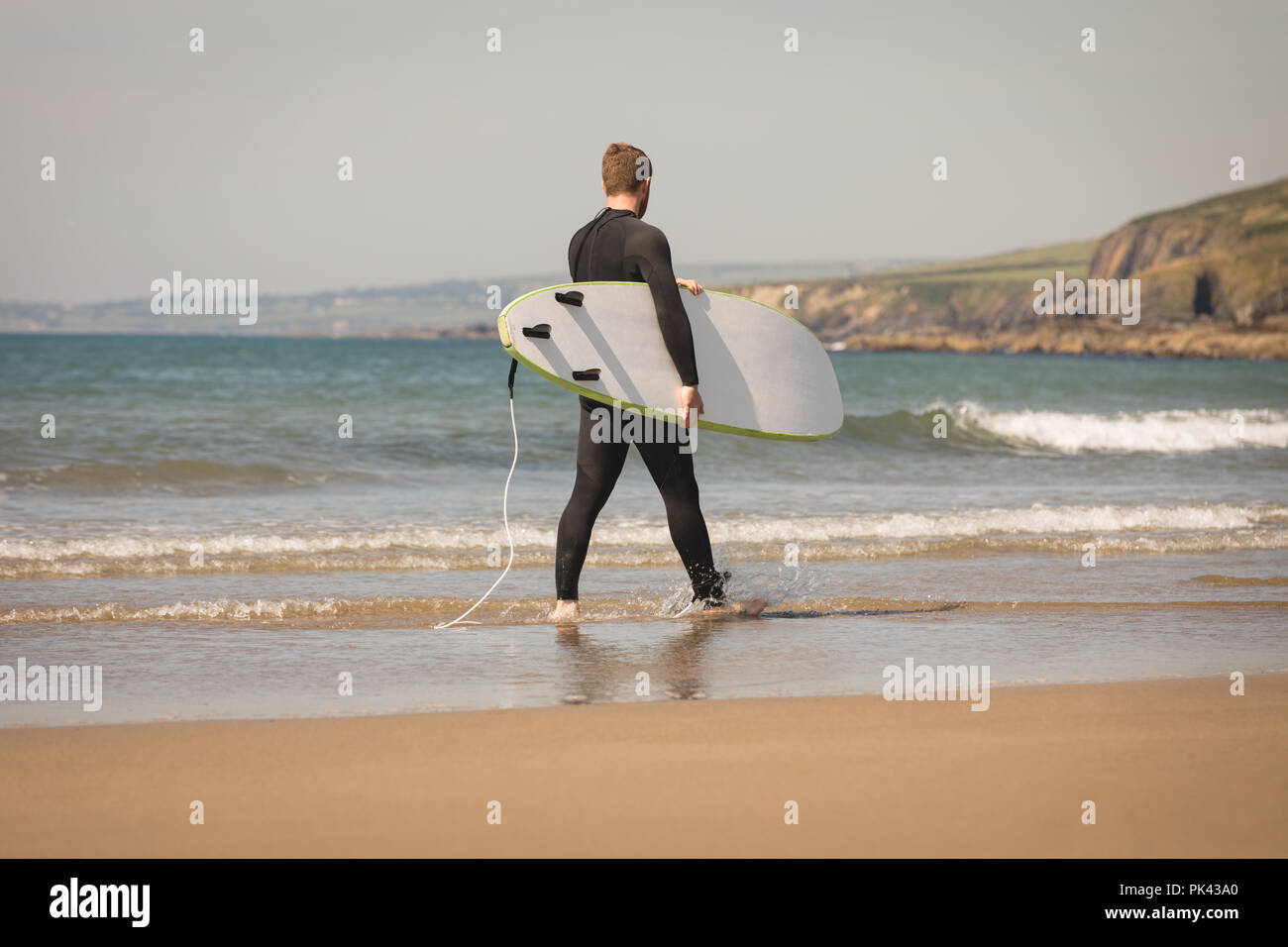 Surfer mit Surfbrett zu Fuß am Strand Stockfoto