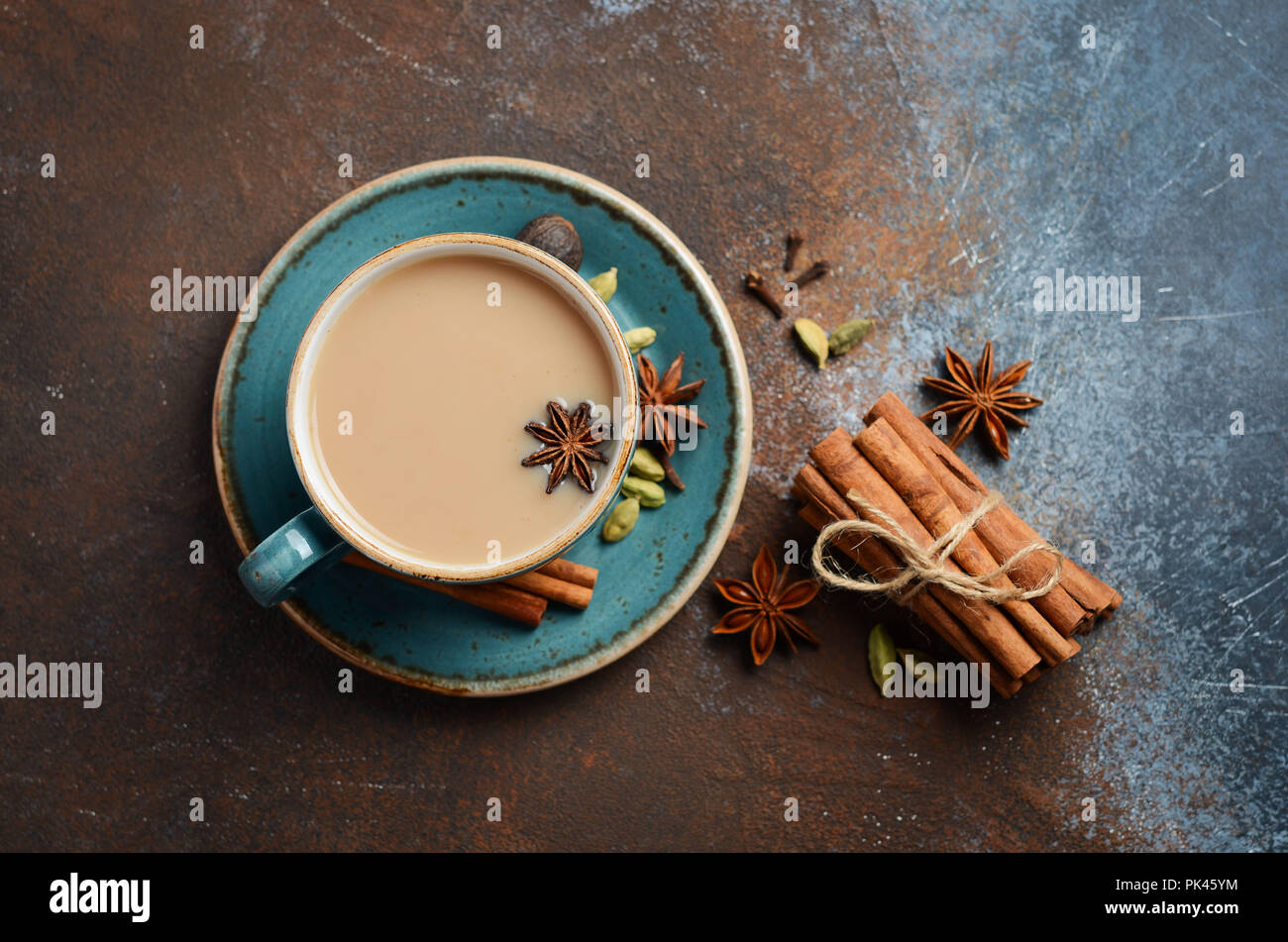 Indische Masala Chai Tee. Gewürzten Tee mit Milch auf dunklen Rusty Hintergrund. Stockfoto