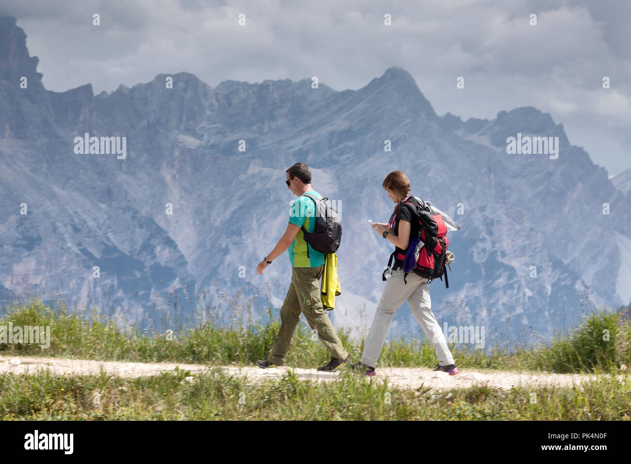 Cortina d'Ampezzo, Italien - 18. August 2018: Ein paar Wanderer, ein Mann und eine Frau mit Rucksäcken auf dem Rücken, Wanderungen auf dem Berg Trail. In der b Stockfoto