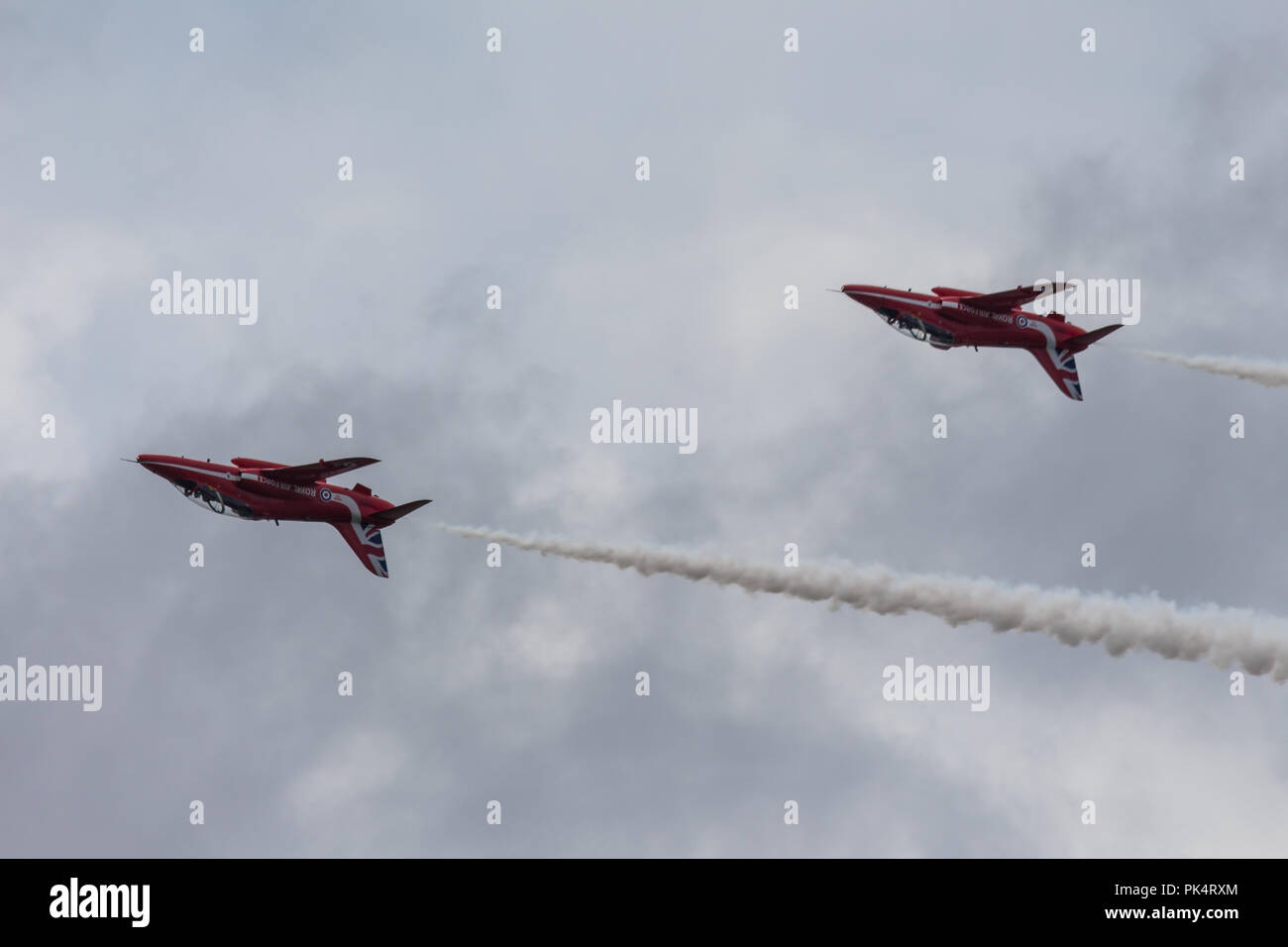 Auf den Kopf gestellt - die roten Pfeile, die Royal Air Force Kunstflug Team, auf der Airshow über Carrickfergus Castle, County Antrim, Nordirland. Stockfoto