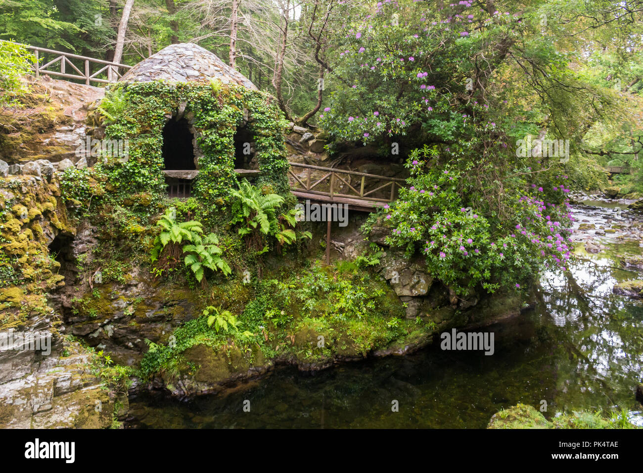 Der Eremitage und dem Fluss, der Eremitage in Tollymore Forest Park, ist ein hübscher Stein Schutz in Efeu bedeckt am Riverwalk neben dem Shimna River, Stockfoto