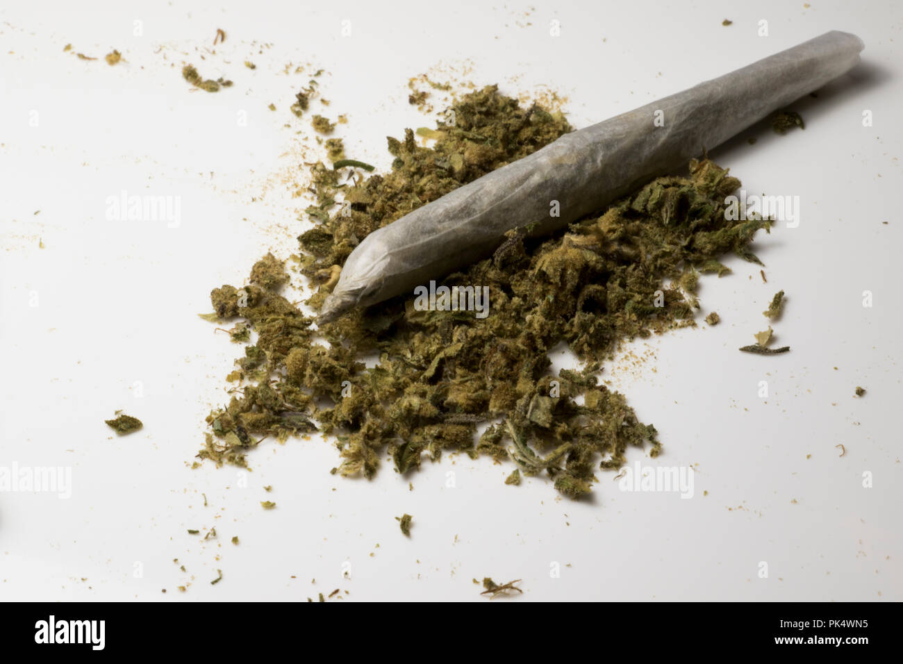 Ganja Anlage. Marihuana Zigarette mit kleiner Haufen von Unkraut. Medizinisches Cannabis. Stockfoto