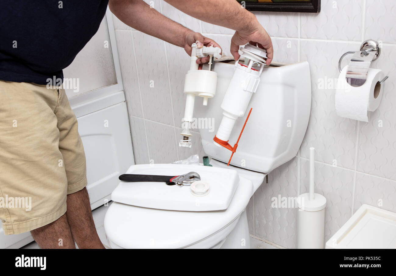 Mann mit Tools, die Instandsetzung der Behälter in ein Bad in einem Konzept der DIY-Reparaturen mit Kopie Raum Stockfoto