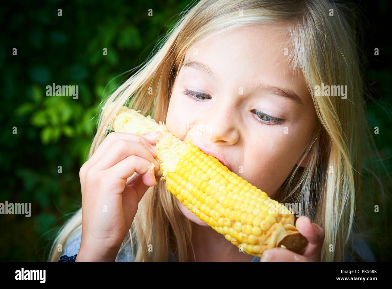 Portrait von Mädchen mit süßen gekochten Mais outdoor Stockfoto