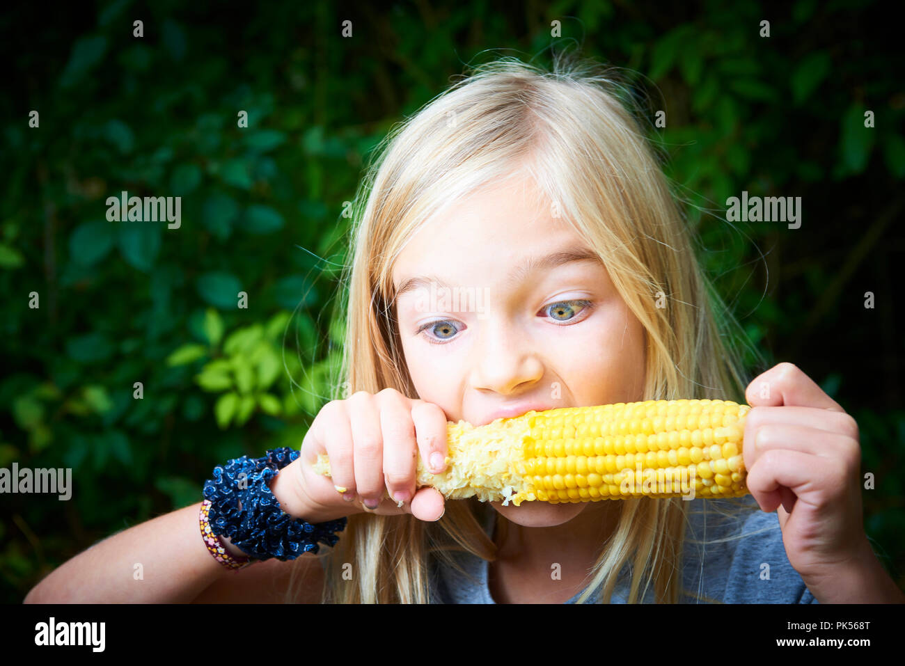 Portrait von Mädchen mit süßen gekochten Mais outdoor Stockfoto