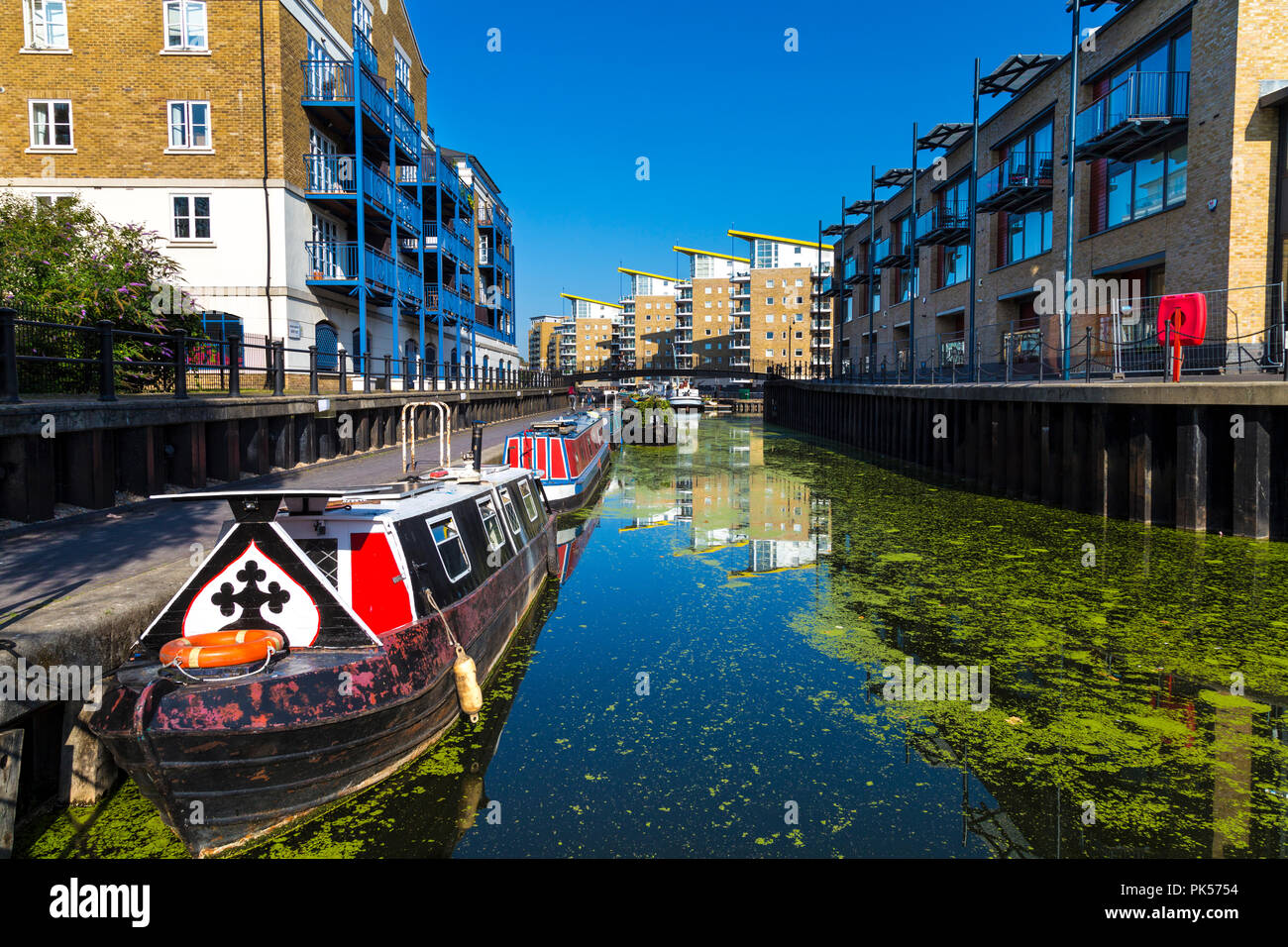 Hausboote und Apartment Blocks durch den Limehouse Cut in den Limehouse Basin, Docklands, London, Großbritannien, Stockfoto