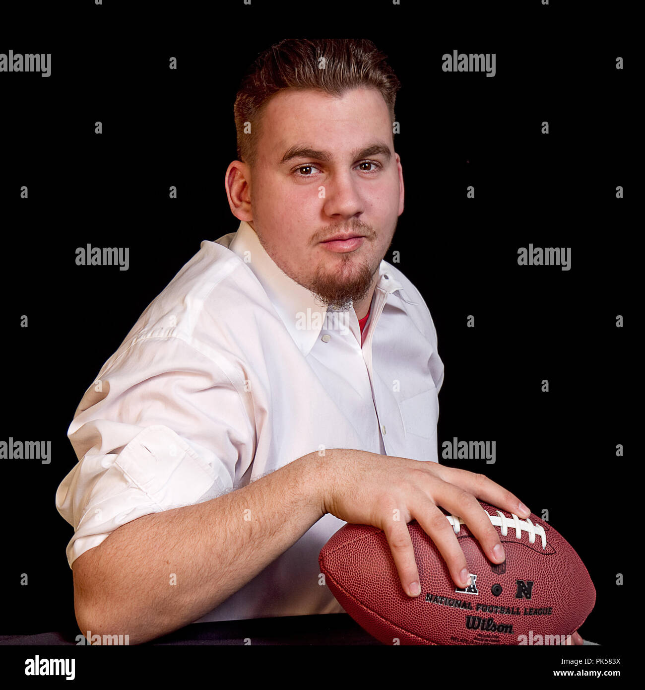 High School ältere männliche Fußballspieler in unterschiedlichen Posen mit Fußball in Bildern enthalten. Einige sind mit seinem Varsity Jacket. Schön und stark Stockfoto