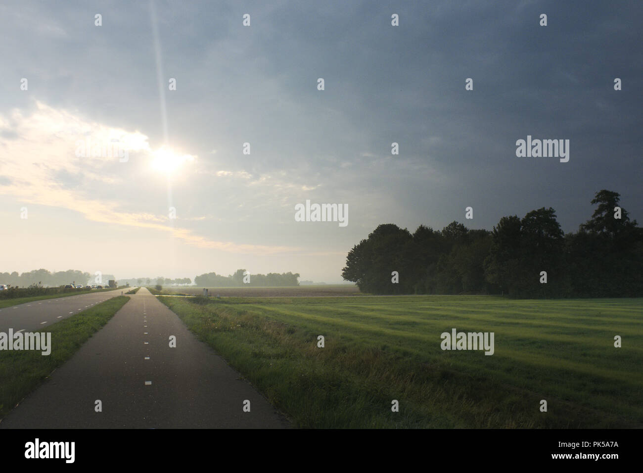 Ansicht auf einem Radweg an einem kühlen Morgen mit der Sonne spähen durch die Wolken. Stockfoto