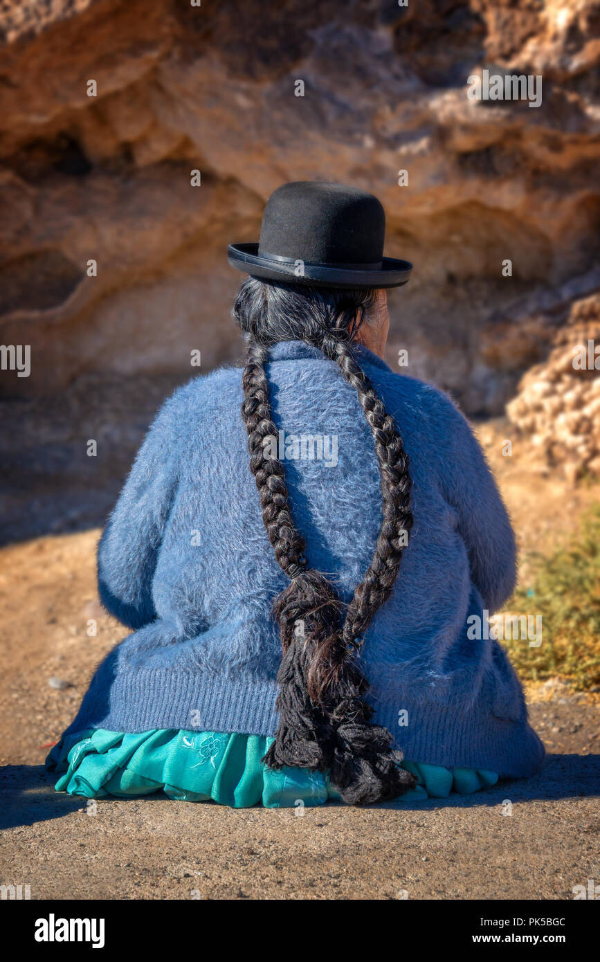 Alte bolivianische Frau im traditionellen Outfit mit Hut und langen Zöpfen Stockfoto