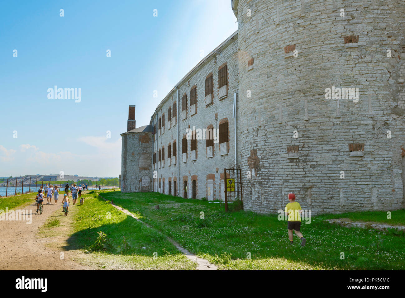 Das Patarei-Gefängnis, an einem Sommernachmittag laufen Menschen am verlassenen und verderblichen Patarei-Gefängnisgebäude im Kalamaja-Erkergebiet von Tallinn, Estland, vorbei Stockfoto