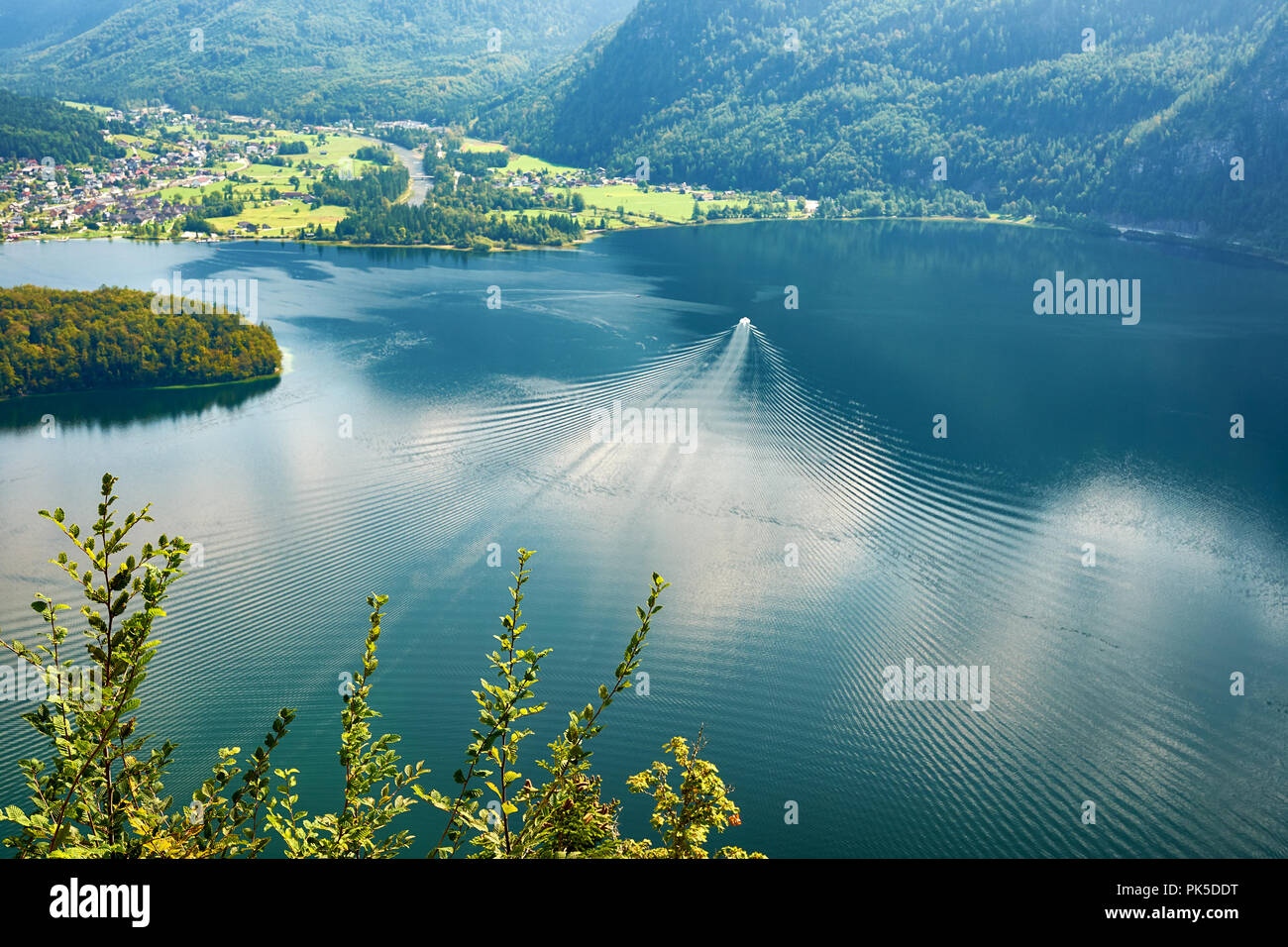 Ausblick auf den See, die Berge und den Wald bei Hallstatt in Österreich. Ein Boot segeln auf dem Wasser Stockfoto