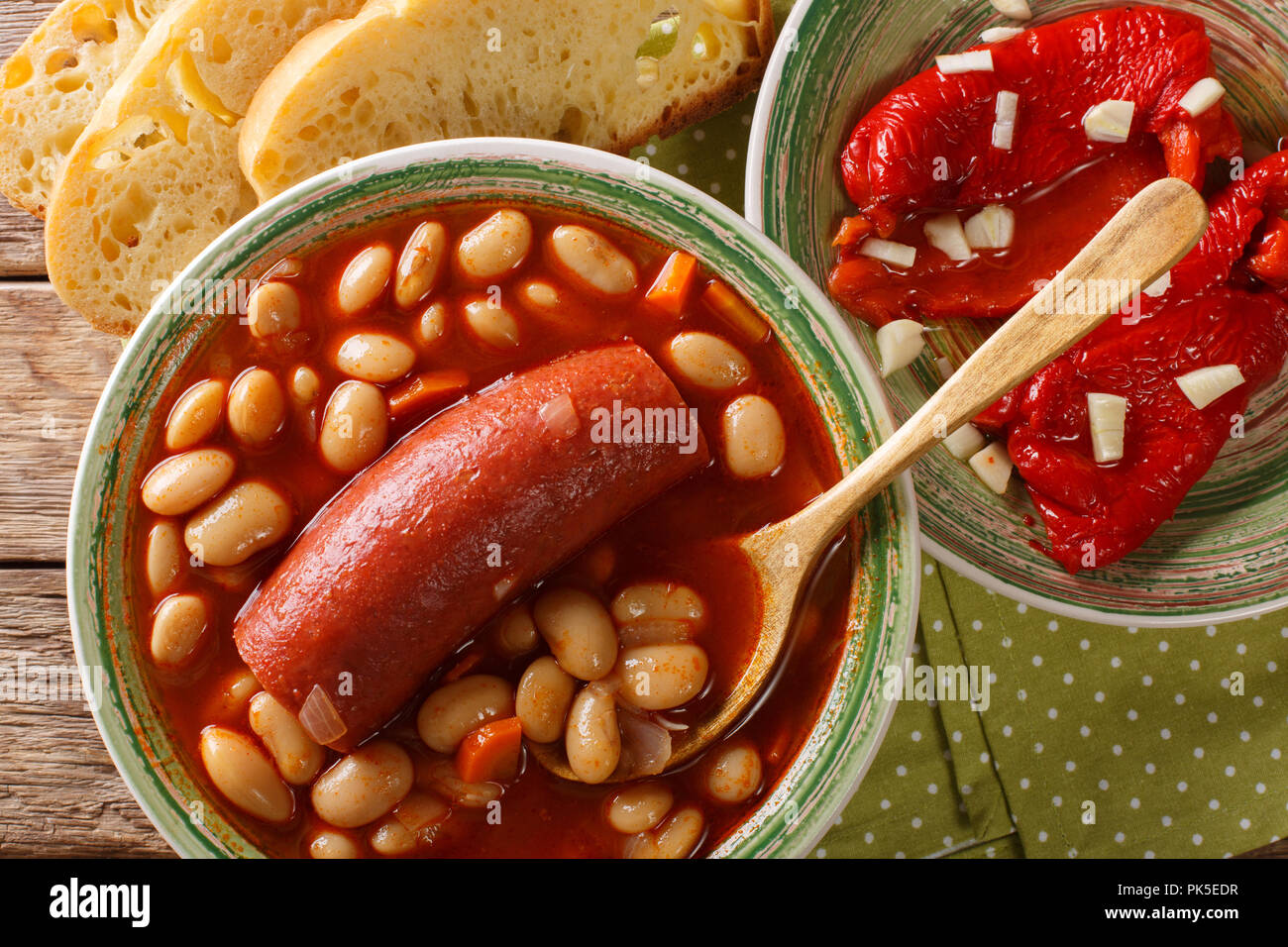 Bohnensuppe mit Wurst mit eingelegten Pfeffer und Knoblauch in der Nähe serviert - oben in der Tabelle. horizontal oben Ansicht von oben Stockfoto