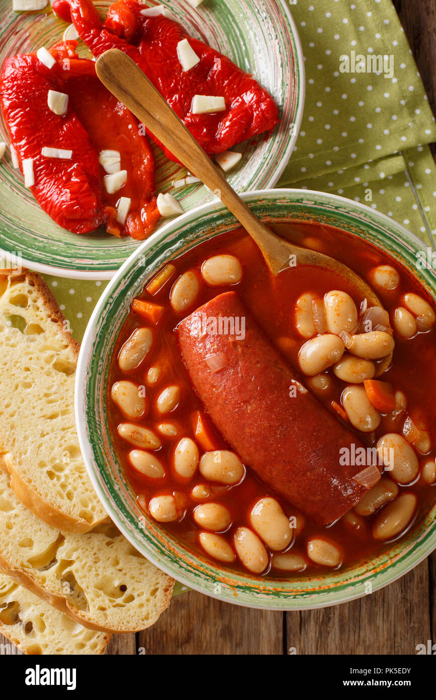 Bohnensuppe mit Wurst mit eingelegten Pfeffer und Knoblauch in der Nähe serviert - oben in der Tabelle. Vertikal oben Ansicht von oben Stockfoto