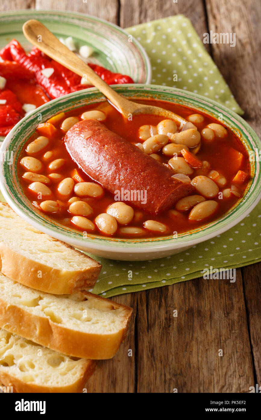 Köstliche pasulj Bohnensuppe mit Wurst mit eingelegten Pfeffer und Brot in der Nähe serviert - auf den Tisch. Vertikale Stockfoto