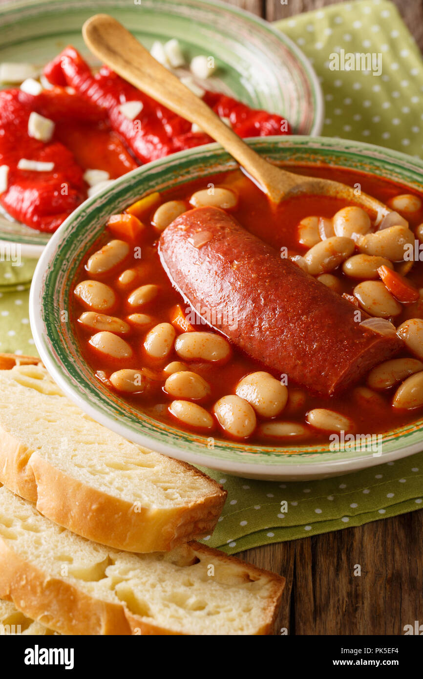 Bohnensuppe mit Wurst mit eingelegten Pfeffer und Knoblauch in der Nähe serviert - oben in der Tabelle. Vertikale Stockfoto