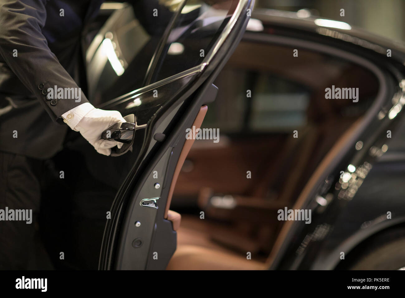 Chauffeur Öffnen der Autotür für Pkw Stockfoto