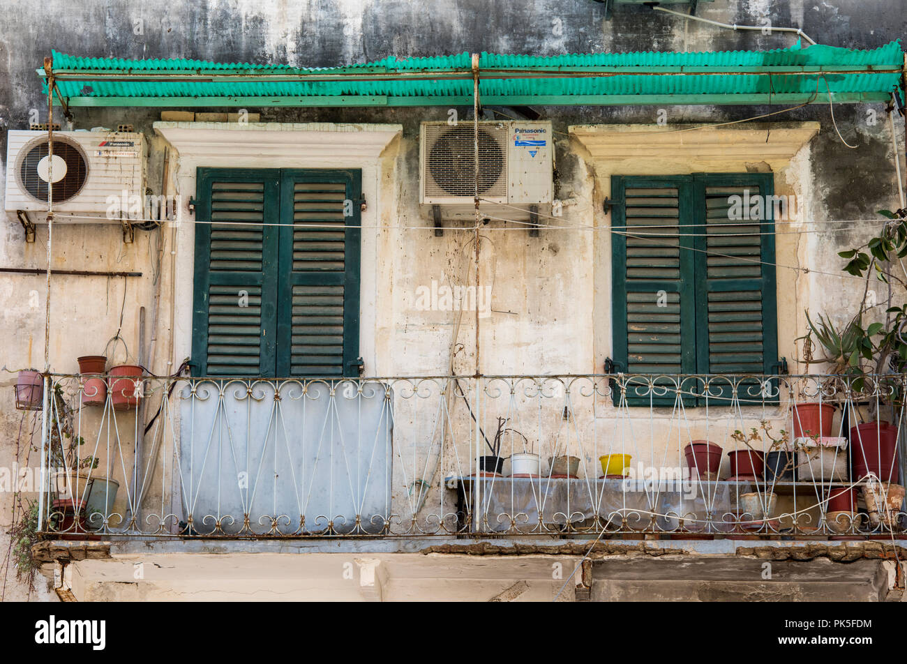 Eine typisch griechische oder typischen Haus oder Wohnung in kerkyra auf der griechischen Insel Korfu in Griechenland. baufälligen Unordnung und Fensterläden aus Holz. Stockfoto