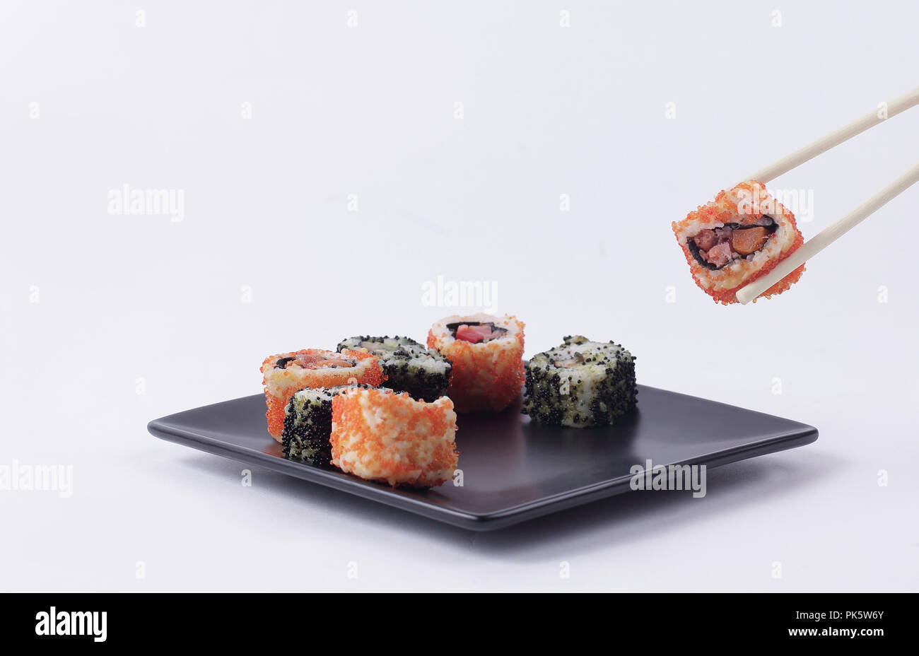 Sushi und Rollen. Der Satz ist auf schwarzem Teller serviert Stockfoto