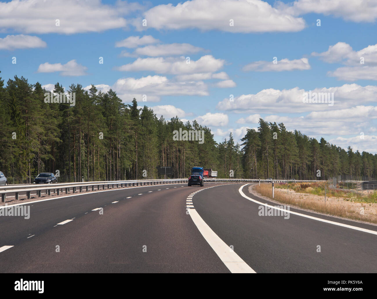 Fahren auf eine schwedische Autobahn durch die Wälder von Värmland an einem sonnigen Sommertag, viel Platz Stockfoto