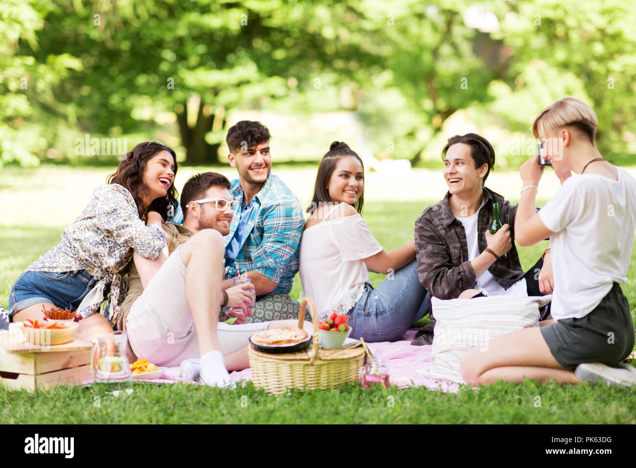 Freunde fotografieren im Sommer Picknick im Park Stockfoto