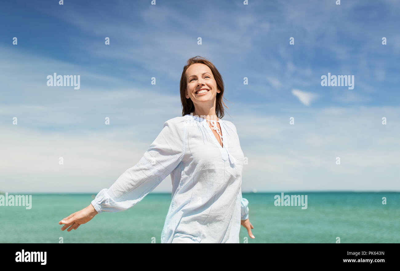 glücklich lächelnde Frau am Sommerstrand Stockfoto