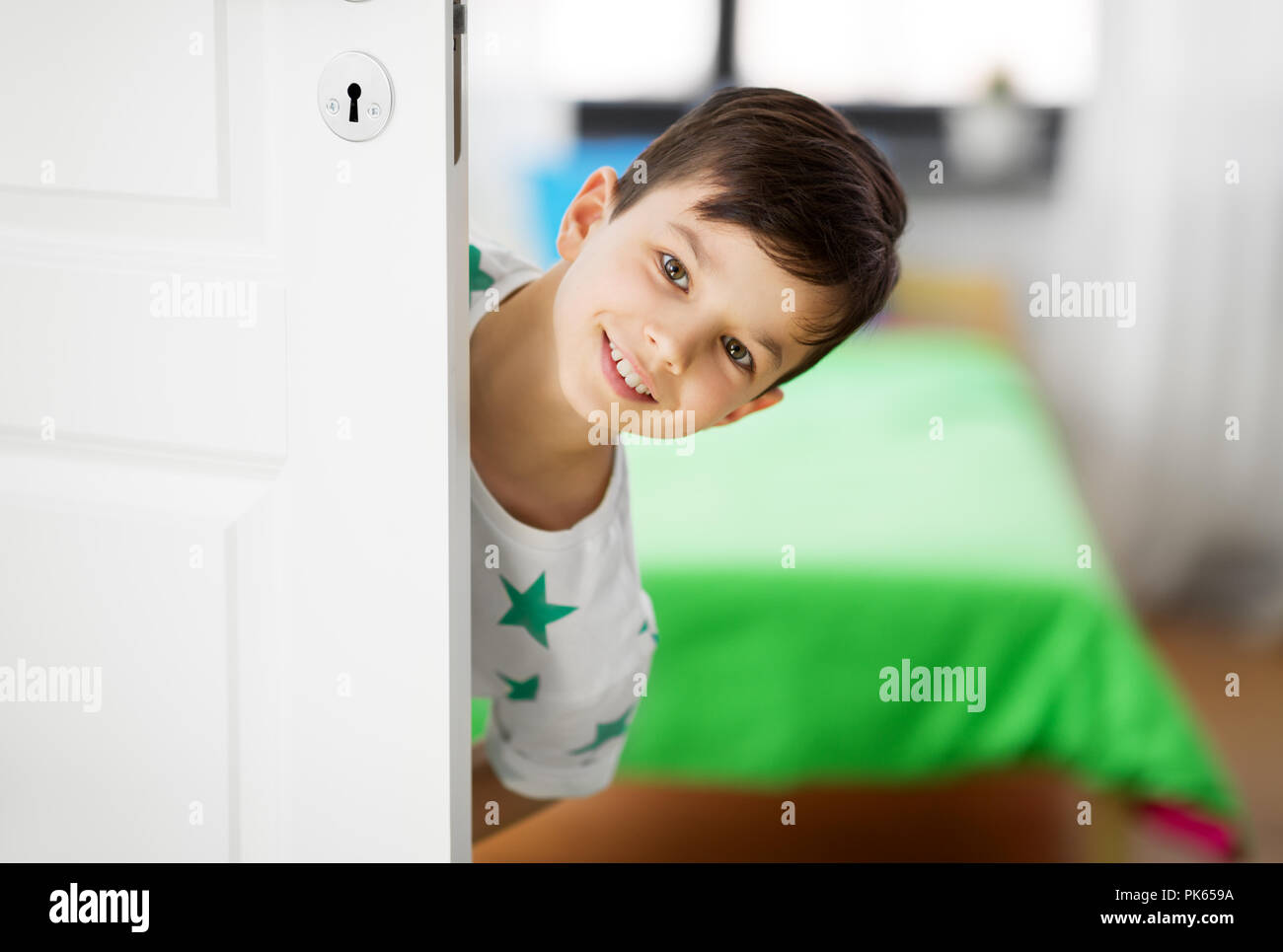 Happy little boy hinter die Tür zu Hause Stockfoto