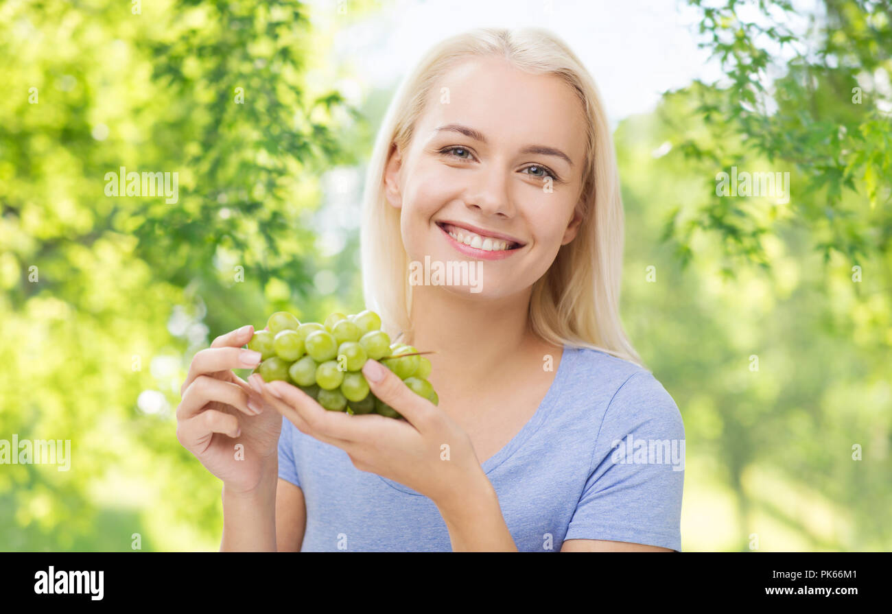 Glücklich lächelnde Frau mit Trauben Stockfoto