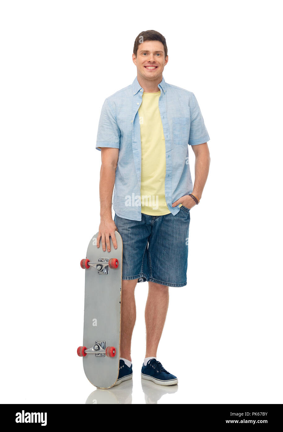 Lächelnden jungen Mann mit dem Skateboard über Weiß Stockfoto