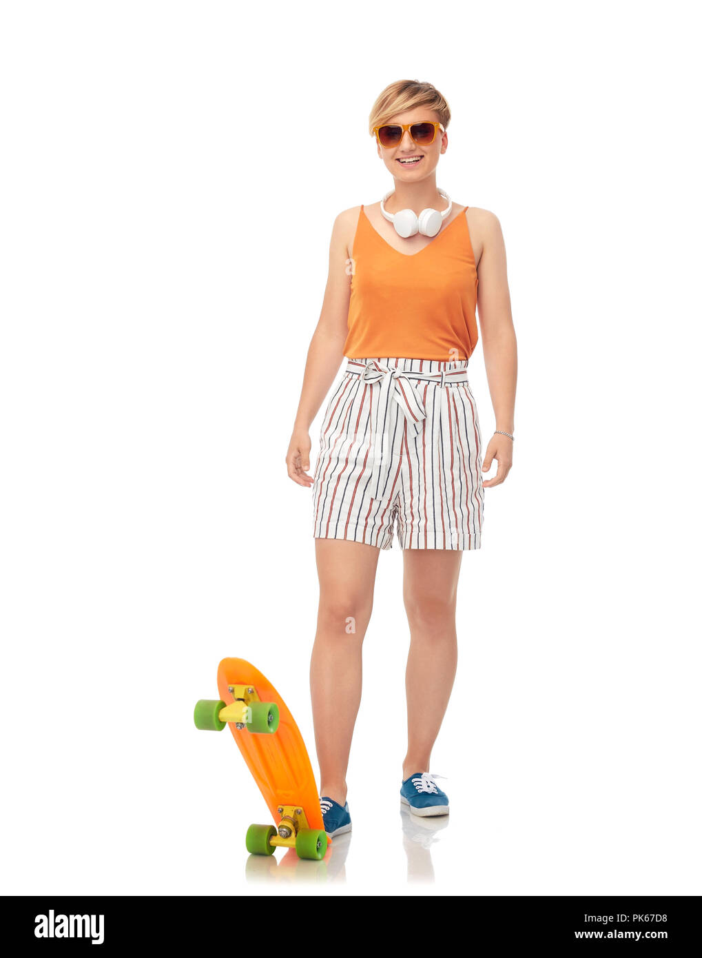 Smiling teenage Mädchen mit Skateboard über Weiß Stockfoto