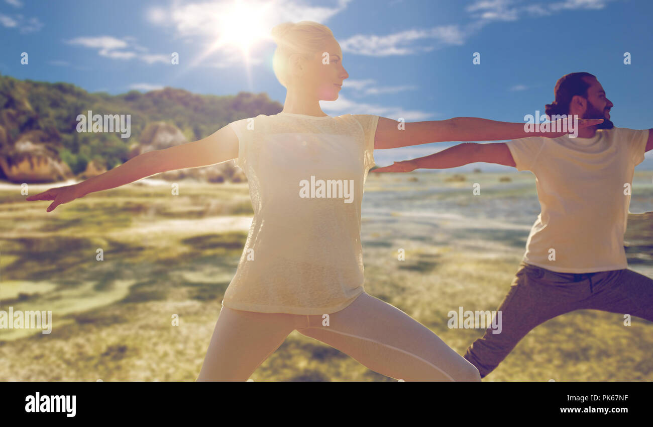 Mann und Frau, die Yoga Übungen am Strand Stockfoto