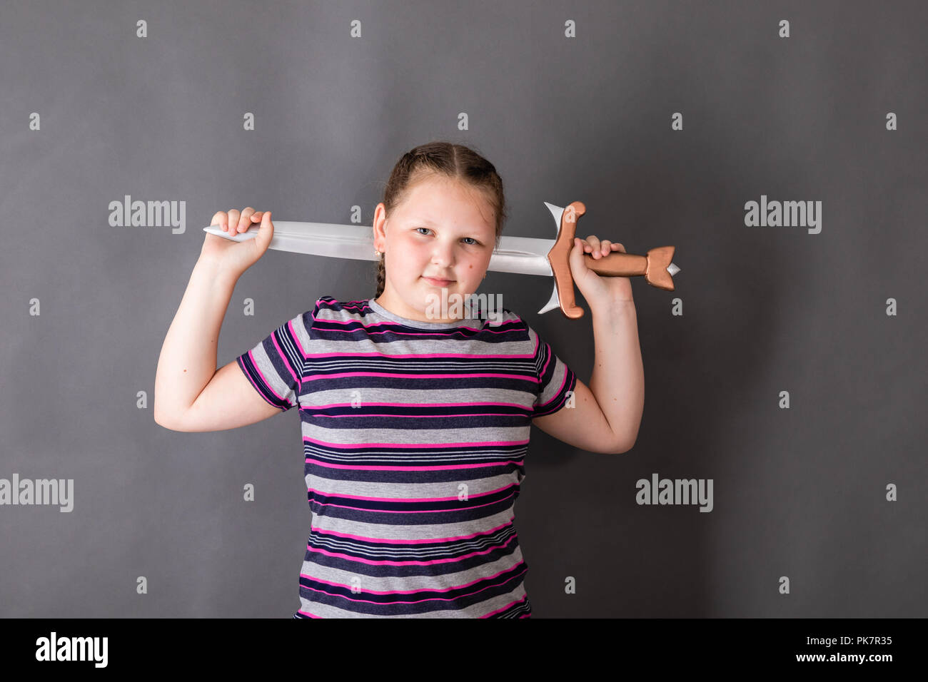 Eine starke, Stout schulpflichtigen Mädchen mit einem Schwert in ihre Arme Stockfoto