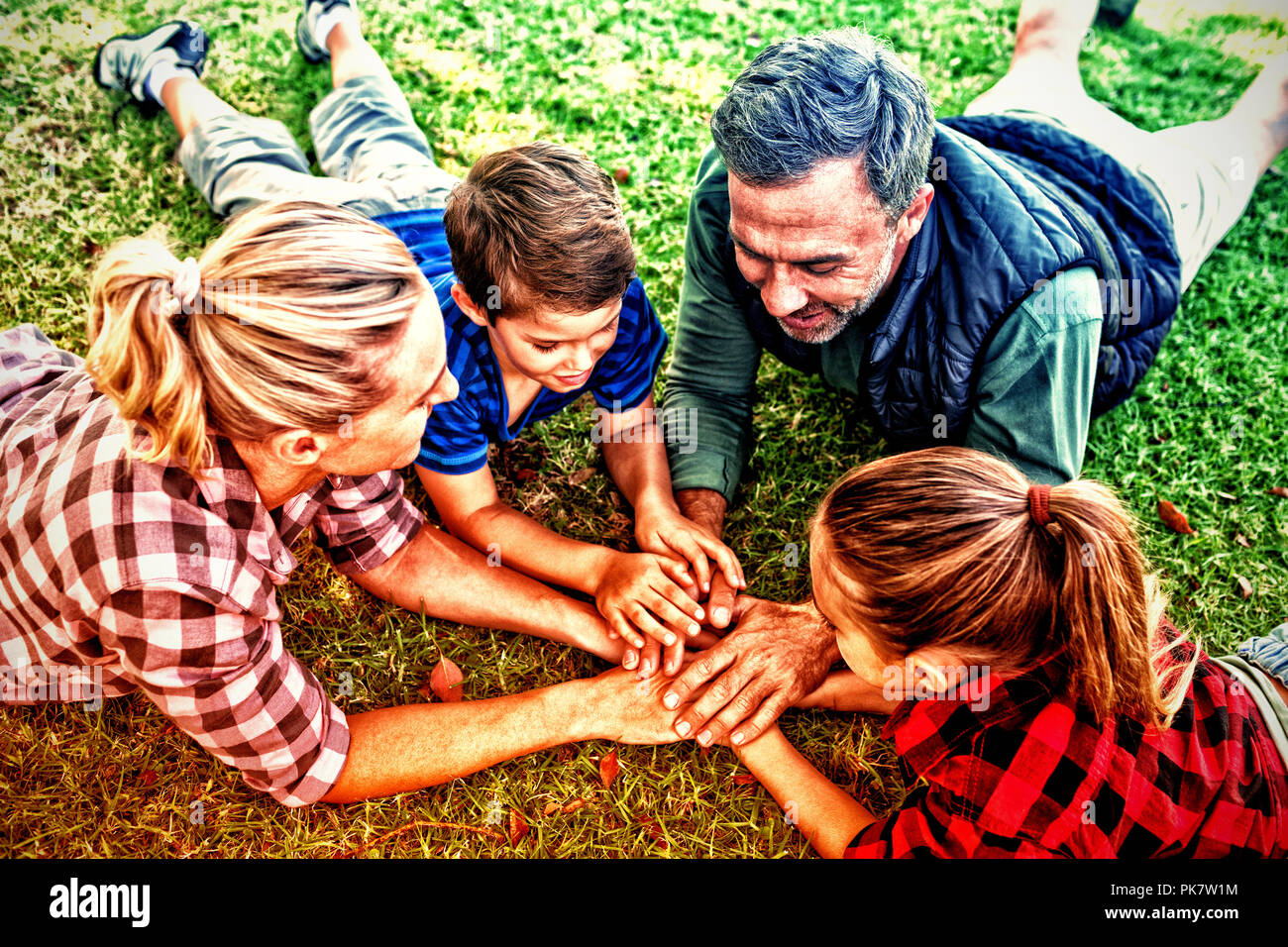 Familie Lügen und ihre Hände zusammen in Park Stockfoto